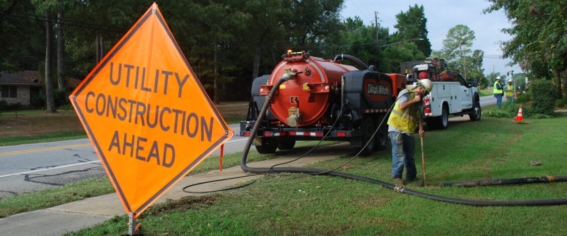 Southern Pipeline employee vacking with safety sign "utility construction ahead" in the foreground