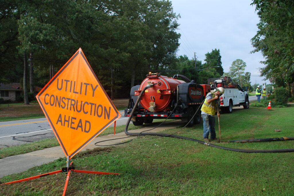 Southern Pipeline employee vacking with safety sign "utility construction ahead" in the foreground